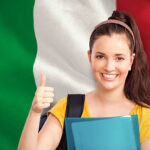 Student with thumbs up against digitally generated italian national flag